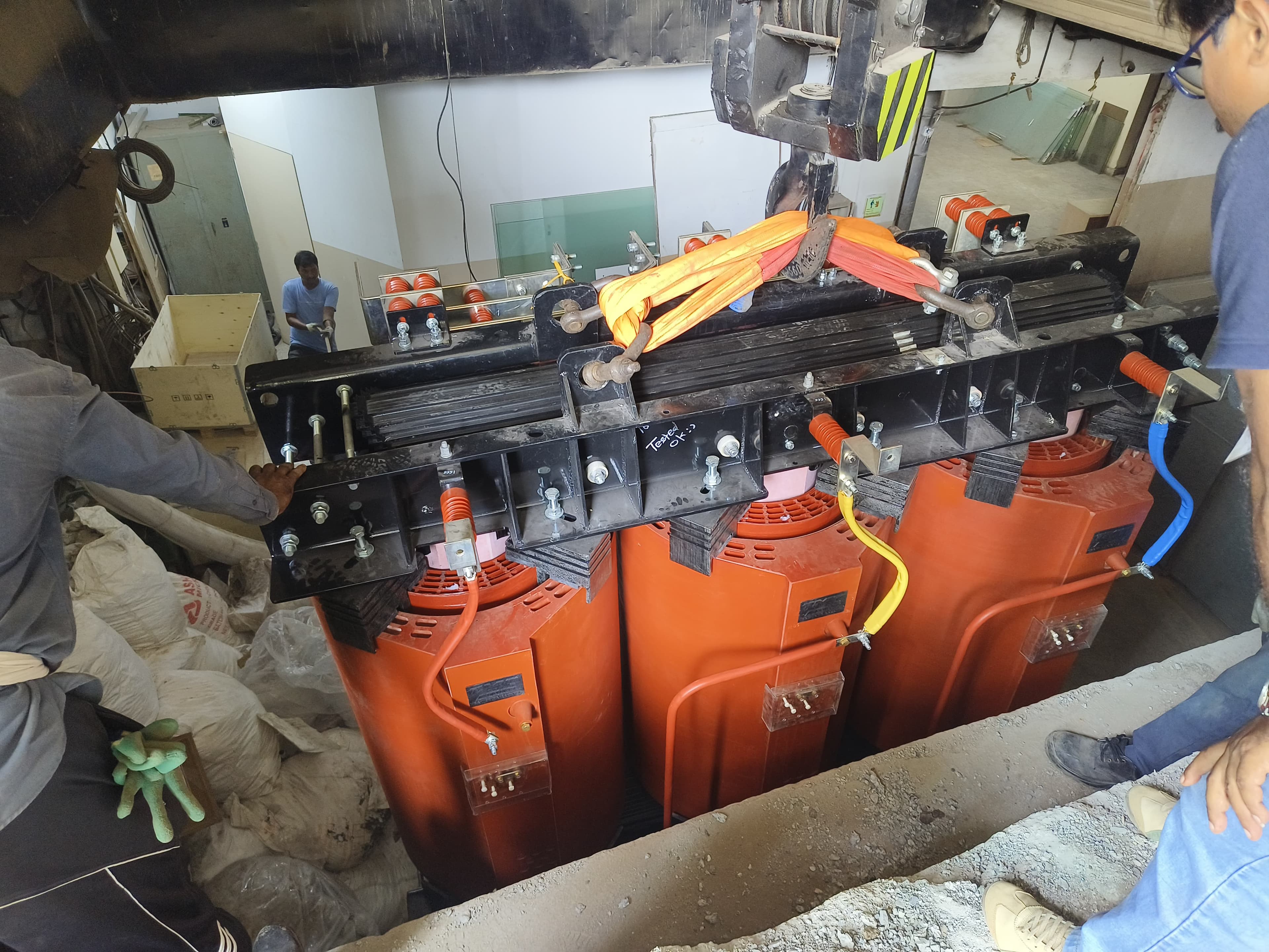 Cast-resin transformer lowered into a basement substation through a single floor opening.